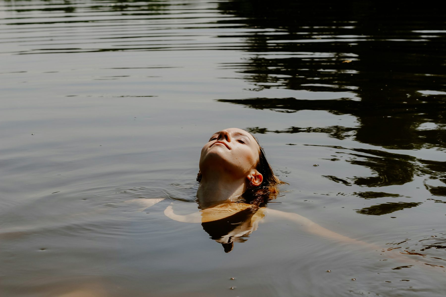 Person floating peacefully in calm water